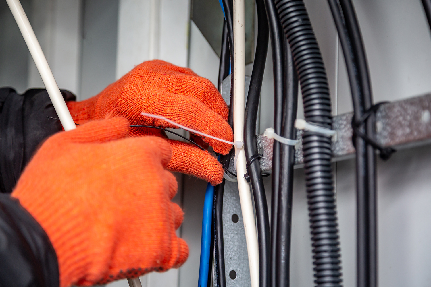 A man securing wires with miniature cable ties.